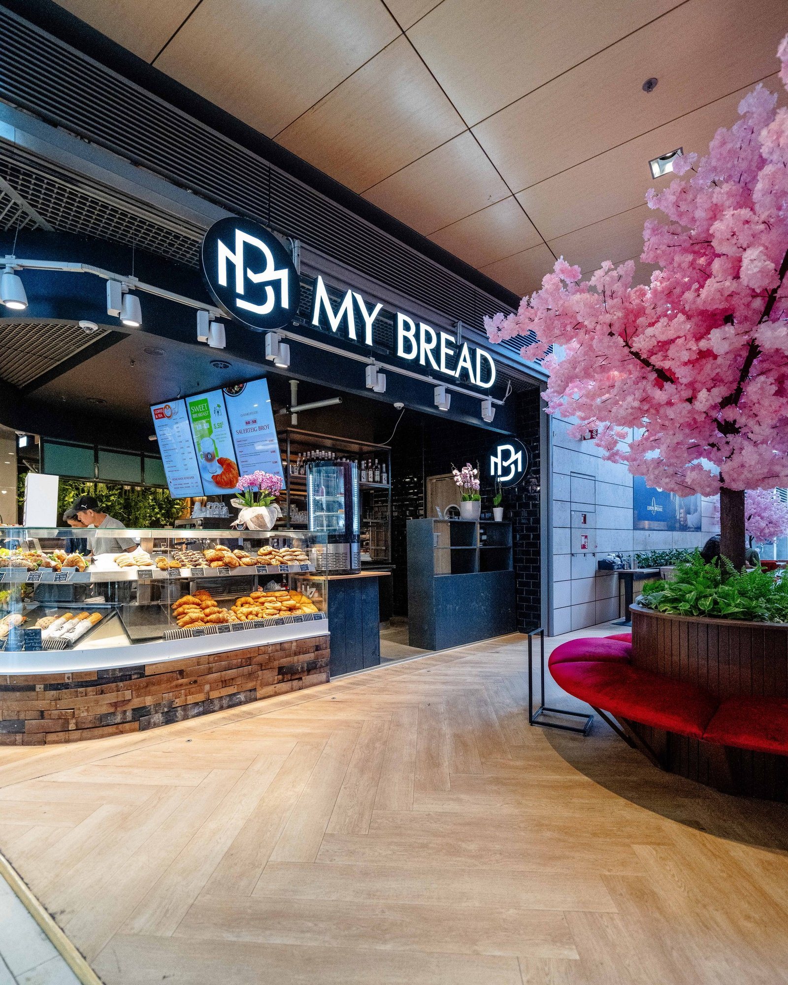 My Bread in der Europa Passage: Leuchtschild, Vitrine mit Croissants und der rosa Kirschblütenbaum davor