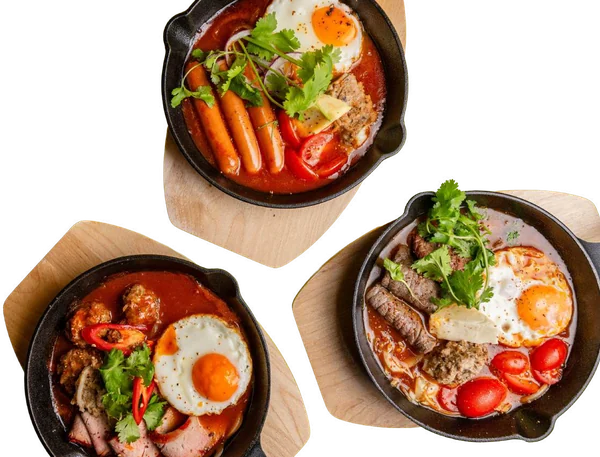 Drei heiße Gusspfannen Bánh Mì Chảo mit Spiegelei, Würstchen, Rindersteak und Baguette